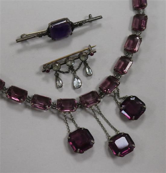 A paste set pendant necklace and two brooches including amethyst.